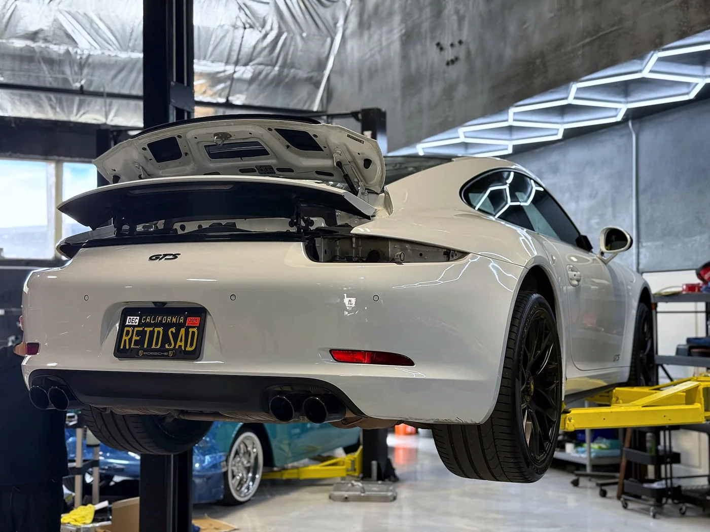 White Ferrari California raised on a lift for service at Artec Automotive