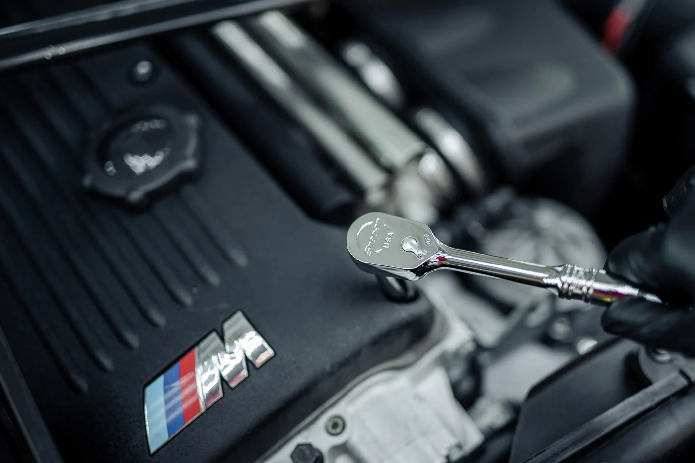 Technician using a Snap-on ratchet on a BMW M engine at Artec Automotive in Belmont, CA